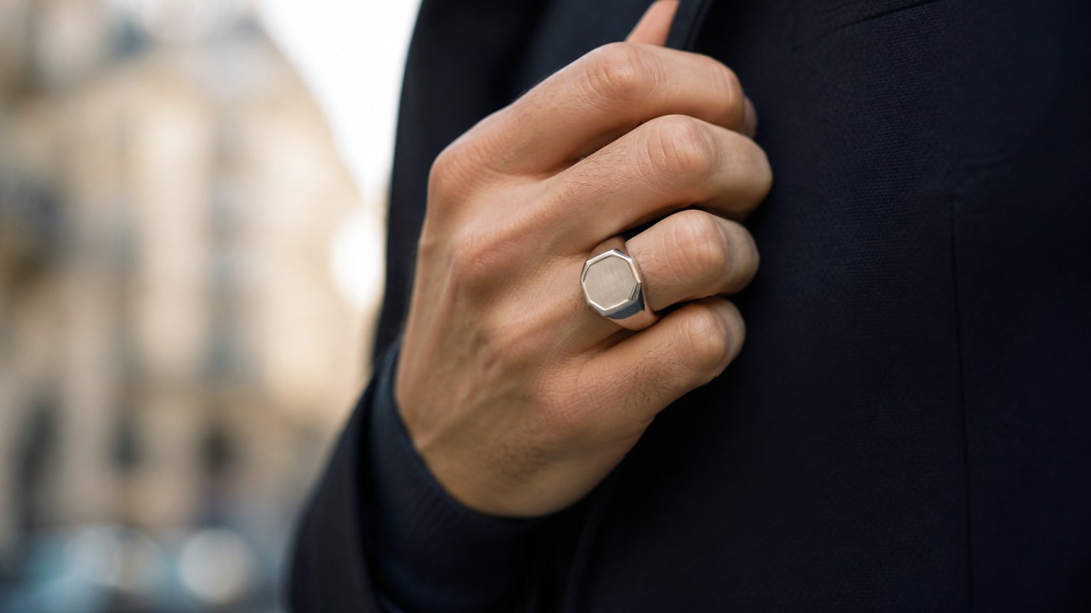 Main d’homme portant une chevalière or blanc 18 carats